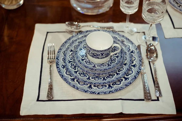 Arrangement of a blue tableware set on a table with a table-cloth in the kitchen