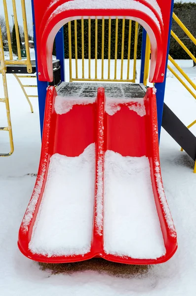 Parco giochi rosso scivolo nella neve — Foto Stock