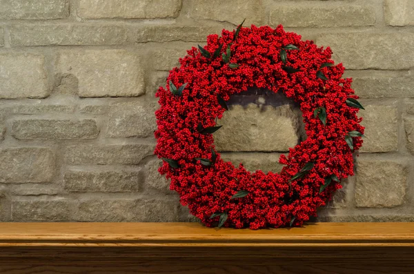 Red Berry Wreath on the right side of a fireplace's mantel
