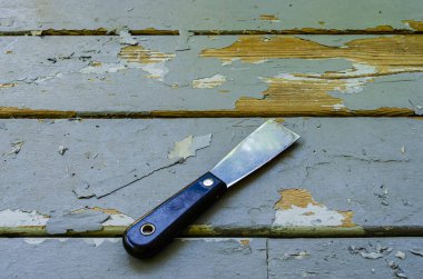 Yatay gri ahşap bir tahtanın üzerinde duran bir macun bıçağının yakın çekimi