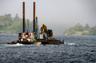 St. Lawrence Nehri 'nde sis kaplı adalarla dolu bir römorkör ve mavna..