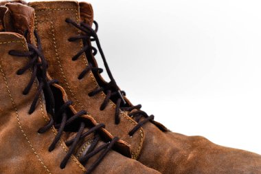 Beyaz arka planda izole edilmiş bir çift kahverengi erkek deri botunun kenarını kapatın.