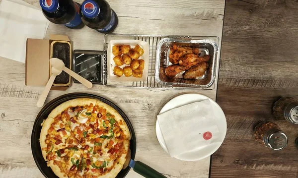  Pizza, tavuk budu ve soğuk içecek şişesi öğle yemeği, kahvaltı, yemek masası konsepti, fotokopi odası. 