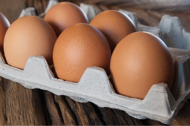 Kahvaltı için tahta masadaki pakette taze yumurta var.