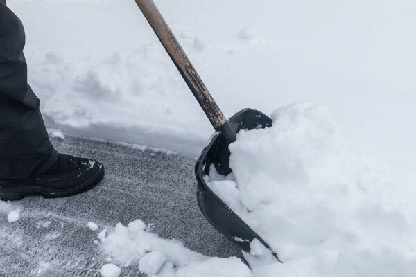 Cleaning suddenly snowed with a shovel near the house