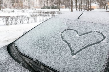 Karlı kalp bir arabanın ön camına boyanır. Yumuşak odak