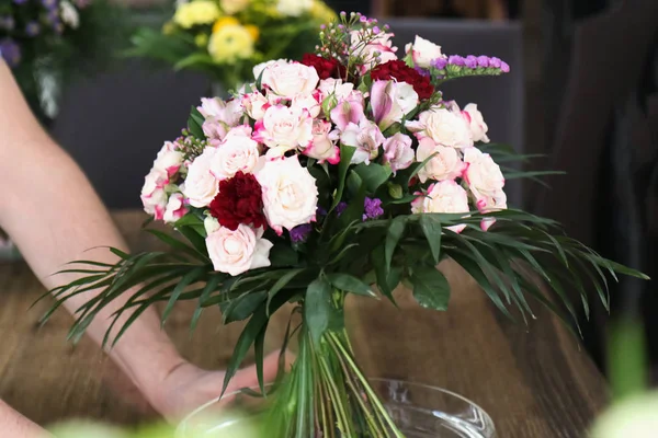 Man chooses a beautiful bouquet in a flower shop — Stock Photo, Image