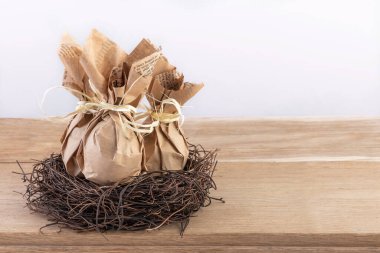 Çevre dostu ambalaj kağıdına sarılmış üç yumurtalı Paskalya Hediyesi. El işi kağıt. Tatillerde yeşil tüketim