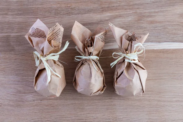 stock image Festive set of Easter eggs wrapped in organic craft paper on a rustic wooden background. Festive table decor. Close-up