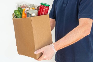 Bir gönüllü, Coronavirus salgınının etkilerinden muzdarip insanlar için yiyecek bağış kutusu tutuyor..