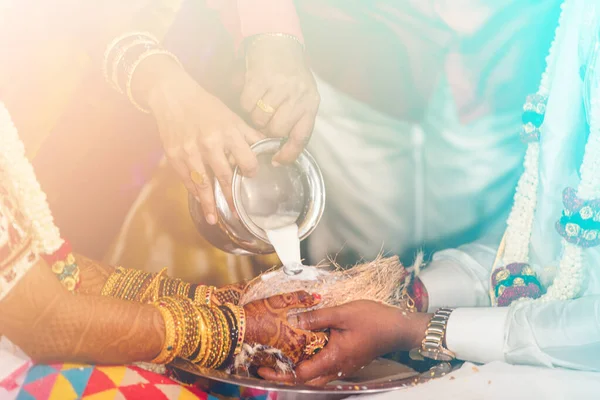 stock image south indian bride and groom holding coconut. milk pouring ritual