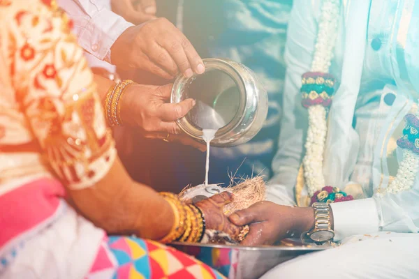 Mariée sud-indienne et marié tenant la noix de coco. rituel de versement du lait Photo De Stock