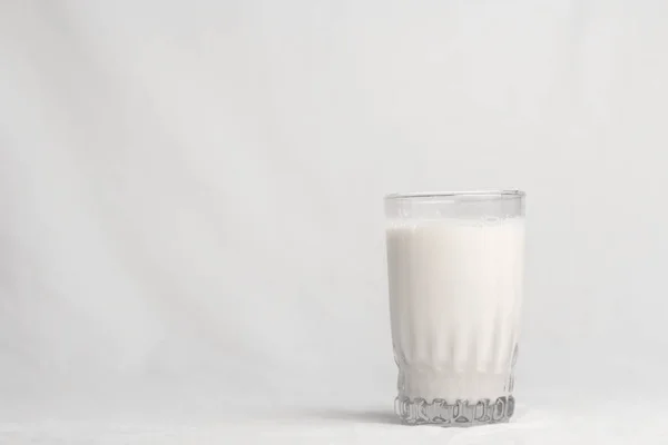 bir bardak süt beyaz zemin üzerine