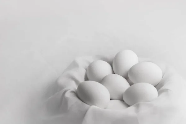 Kumaş yuvasında bir grup beyaz yumurta. Yaklaş.