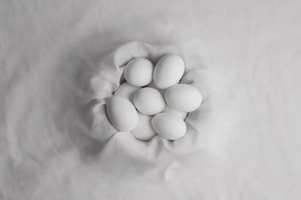 Kumaş yuvasında birkaç beyaz yumurta.