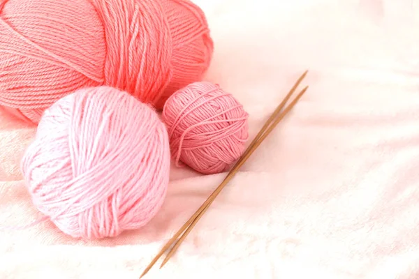  pembe iplik topları ve örgü iğneleri