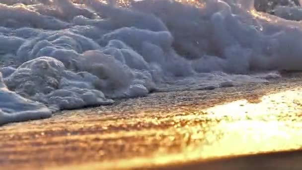 Onda de praia salpicando macro no pôr do sol câmera lenta — Vídeo de Stock