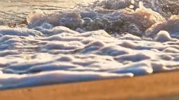 Onda de praia salpicando macro no pôr do sol câmera lenta — Vídeo de Stock