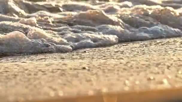 Onda de praia salpicando macro no pôr do sol câmera lenta — Vídeo de Stock