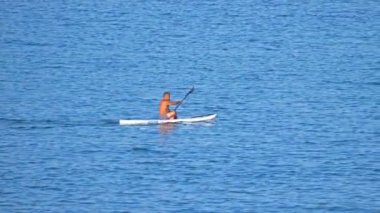 Karayip mavisi deniz 4k 'de kano süren bir adam.