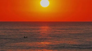 Büyük güneş denizin üzerinde, kırmızı gökyüzü yavaş çekim 4k