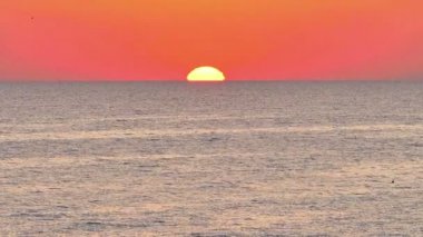 Büyük güneş denizin üzerinde, kırmızı gökyüzü yavaş çekim 4k