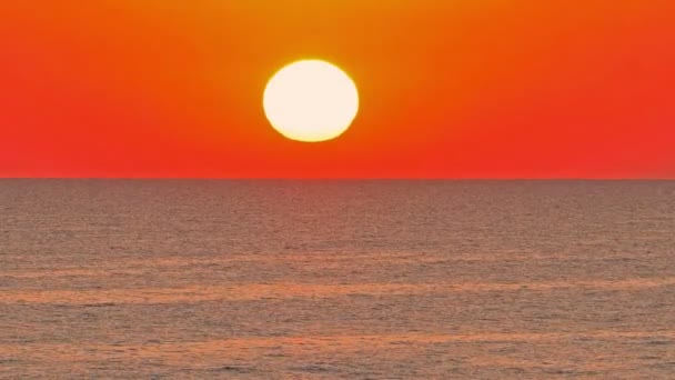 Sol grande abajo sobre mar, cielo rojo cámara lenta 4k — Vídeos de Stock