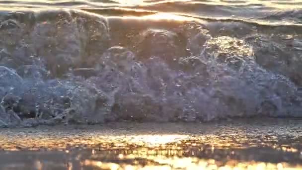 Ola de playa salpicando macro en puesta de sol — Vídeo de stock