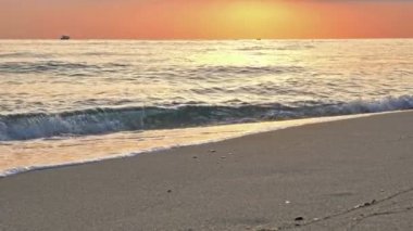 Sahil dalgası günbatımında makro su sıçratıyor.