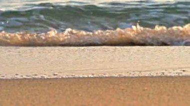 Sahil dalgası günbatımında makro su sıçratıyor.