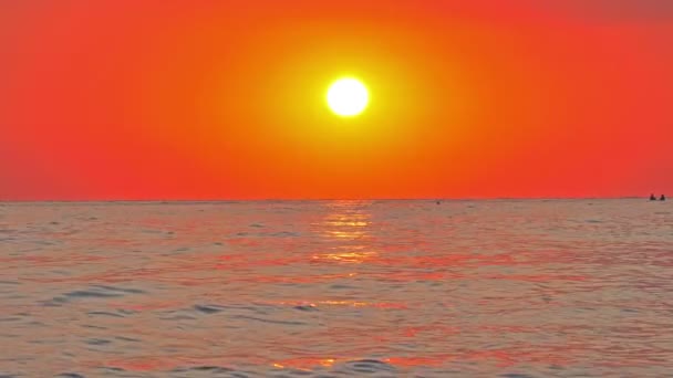 Sol grande abajo sobre mar, cielo rojo cámara lenta 4k — Vídeos de Stock