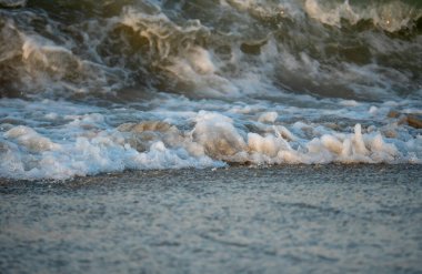 Dalgalar deniz kıyısı makrosu sıçratıyor. Yaklaş.
