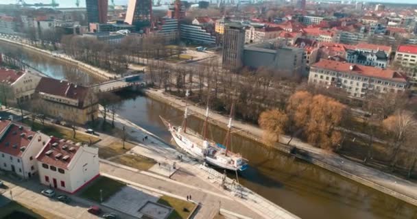 KLAIPEDA, LITHUANIA - MARCH 12, 2017: AERIAL. Drone orbit mode shot around old ship-restaurant "Meridianas" in Danes river in old town of Klaipeda on a sunny spring day. Klaipeda, Lithuania. — Stock Video