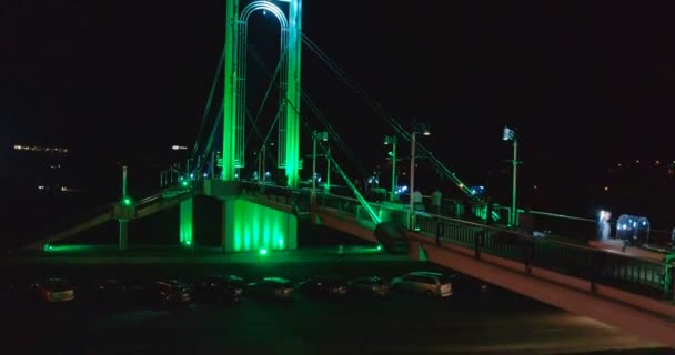 Luchtfoto. Soepele kantelbare drone schot van Simonas Daukantas brug verlicht in verschillende kleuren in de nacht in Kaunas, Litouwen. 4k. — Stockvideo