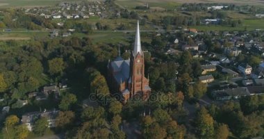 Hava. Yumuşak noktayı faiz dron atış St John Kilisesi Ramygala Litvanya. Erken sonbaharda şehir panoraması. 4k