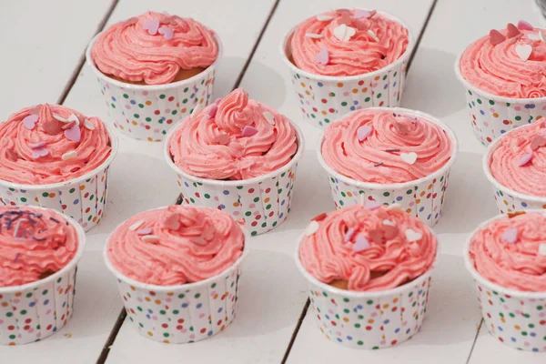 Ein schöner Cupcake mit Sahne und Herzen auf weißem Hintergrund — Stockfoto