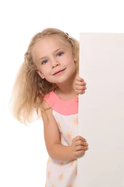 Little girl peeks out from behind a white sheet on a white backg — Stock Photo, Image