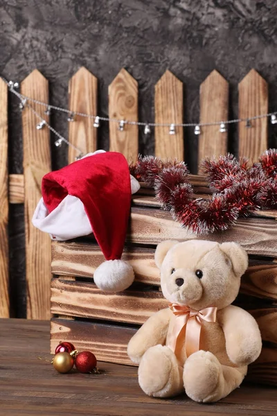 Teddybär, Weihnachtsmann-Hut, Lametta auf dem Hintergrund eines Waldes — Stockfoto