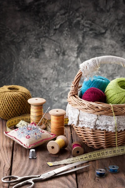 Tangles of thread in a basket, scissors and threads in reels on — Stock Photo, Image