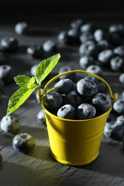 成熟的蓝莓 装在灰色背景的小装饰黄色桶中 — 图库照片