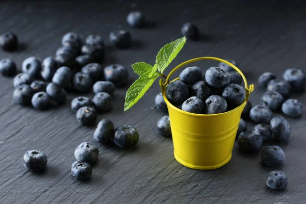 Ripe Blueberries Small Decorative Yellow Bucket Gray Background — Stock Photo, Image