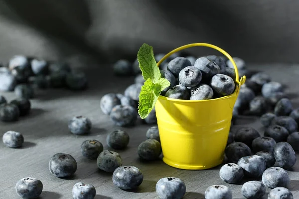 成熟的蓝莓 装在灰色背景的小装饰黄色桶中 — 图库照片