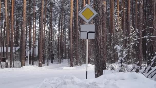 Verkehrszeichen eine Vorfahrtsstraße im verschneiten Wald — Stockvideo