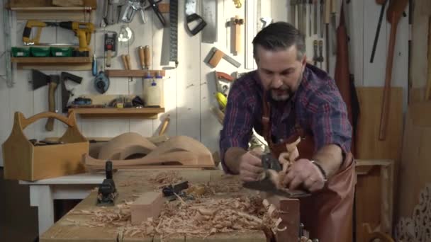 Schrijnwerker vliegtuigen massief hout in zijn atelier — Stockvideo