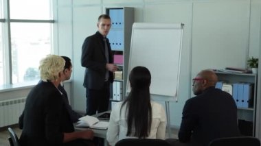 Ne sonuçlar geldin? /In büyük pencereler ekibi ile geniş office mali rapor anlatılmaktadır. Tablet, dizüstü bilgisayar ve kalem masanın üzerinde. Onlar iş takım elbiseli giyindin. Onlara, büyük pencereler, dolaplar klasörlerle, bir flipchart