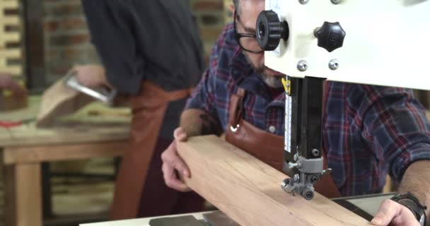 Volwassen meubelmaker maakt een been van de Cabrioli met behulp van bandzagen — Stockvideo