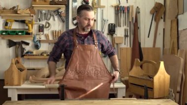 Kabine Maker Doğramacılar dükkânının için onun/Cabinet-maker çalışma günü geliyor başlar önlük üzerinde koyar, cabrioli masanın bacağına alır ve çalışmaya başlar