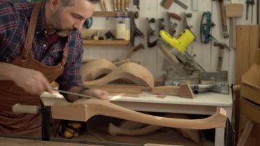Marangoz cilalar Cabrioli bacak onun atölye/kabine Maker cabriolet bacak bir dosyayla parlatıyor. O küçük aile Doğramacılar dükkanında çalışıyor