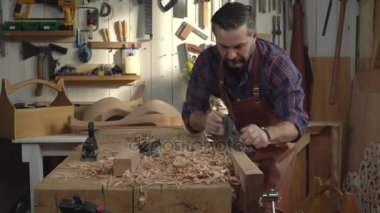 Onun atölye/kabine Maker Joiner uçaklar masif ahşap kayın tahta bir uçakla uçakları. O küçük aile Doğramacılar dükkanında çalışıyor