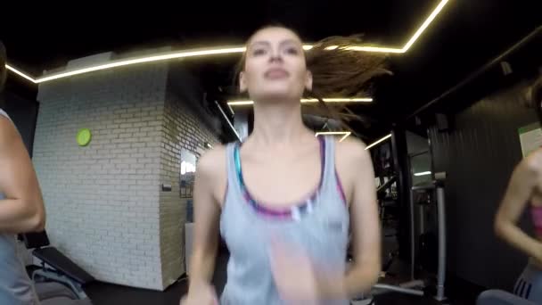 Молодая женщина бежит на беговой дорожке (медленное движение ) — стоковое видео